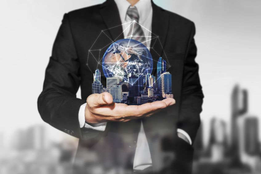 Businessman holding modern buildings with global network connection. Elements of this image are furnished by NASA