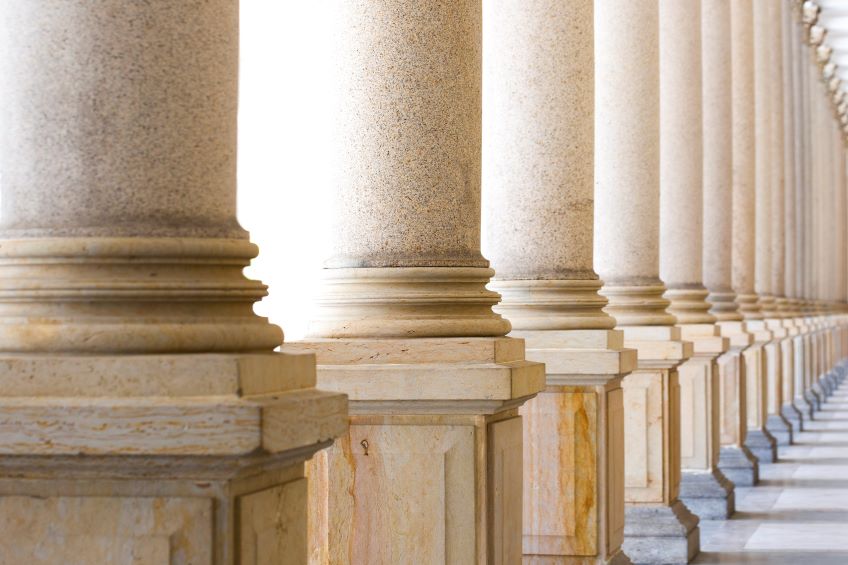 A series of large, round stone columns receding into the distance