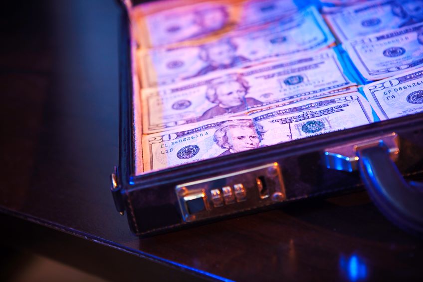 A close-up view of a briefcase filled with stacks of U.S. 20-dollar bills