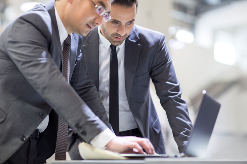 two businessmen looking at a laptop