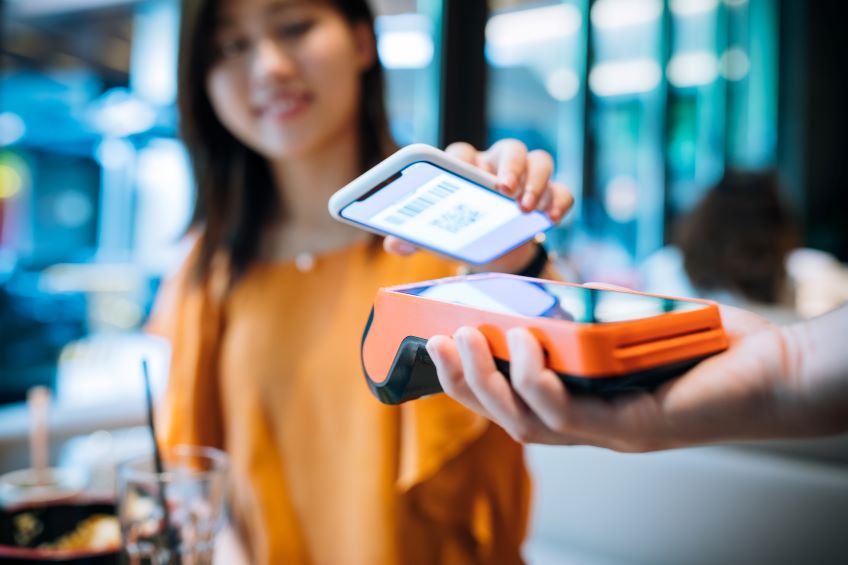 Close up of woman holding her phone to scan for a purcahse