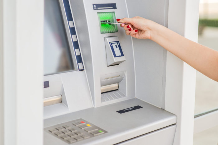 Businesswoman with credit card, Woman inserting a credit card to ATM